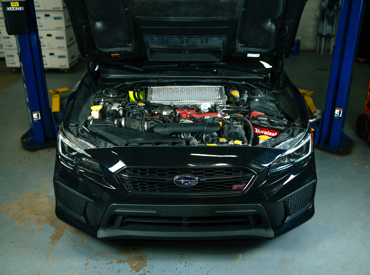 Subaru WRX STI engine bay on a lift in the OAKOS service shop