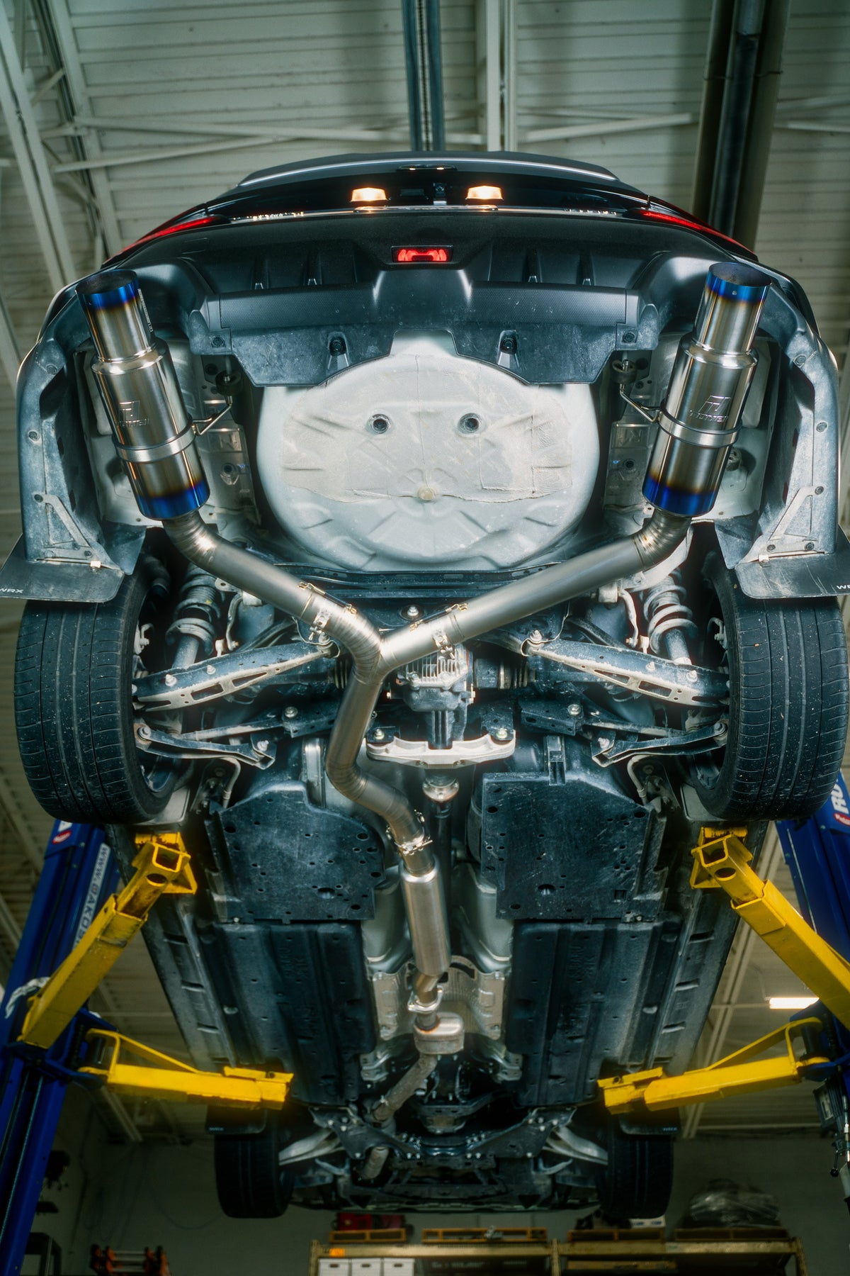 Underside of a Subaru showing an aftermarket exhaust system installed at OAKOS
